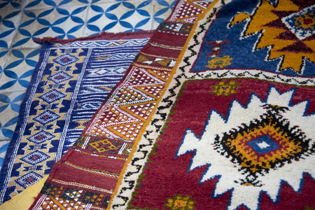 Colourful hand woven berber carpets spread on the bazaar floor in Moroccoの写真素材