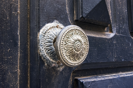 Antique door handle in flower pattern. Worn and dirtied over timeの写真素材