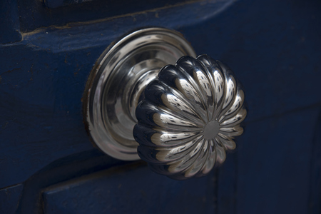 Essaouria, Morocco - September 2017: Antique silver doorknob - polished to a shine by years of use mounted on a blue doorのeditorial素材