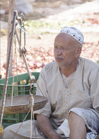 Essaouria, Morocco - September 2017: A farmer sits waitnig to sell his produce at the weekly berber open market outside Essaouira in Morocco. Women rarely attend a market like this one.のeditorial素材