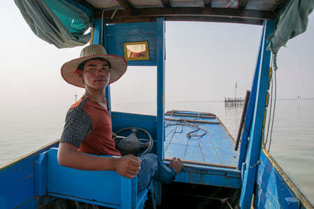 Cambodia, Tonle Sap Floating Village - March 2016: Man reversing water taxiのeditorial素材