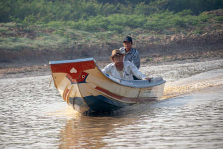 Cambodia, Tonle Sap Floating Village - March 2016: 2 men travelling in a traditional long boat, water taxiのeditorial素材