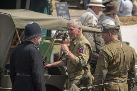 UK, Quorn - June 2015: Men dressed in wartime uniforms talking together during Victoryのeditorial素材