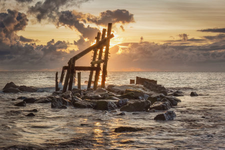 UK, NORFOLK - Eroded war time defences stnad silhouetted agains the dawnの写真素材