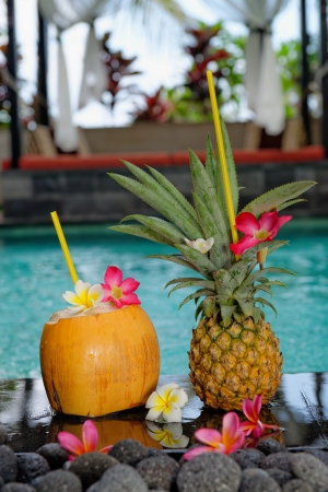 Tropical cocktails by the pool, Nicely decorated coconut and pineapple cocktails on pool side in luxury villa on Bali island の写真素材