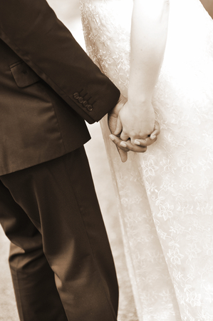 Bride and groom holding his hands の写真素材