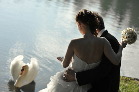 young wedding couple, beautiful bride with groom portrait on the bridge, summer nature outdoor の写真素材