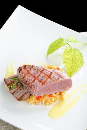 Fine dining / Medium rare sashimi tuna steak on saffron risottoの写真素材