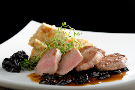 Venison steak cuts on a chestnut puree with dried plumsの写真素材