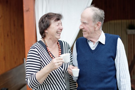 Senior Couple Enjoying Snack At Outdoor Cafe