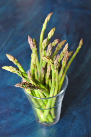 Bunch of fresh asparagus on wooden tableの写真素材