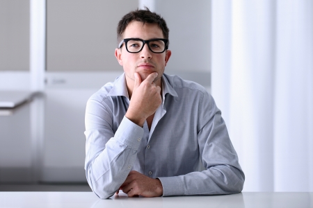 Man in home office with thoughtful lookの写真素材