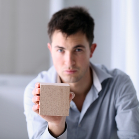 Man showing a wooden cubeの写真素材