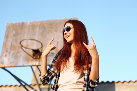 girl showing symbol of rock musicの写真素材