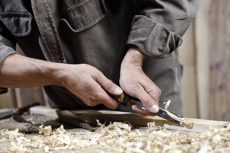 carpenter with chisel in the hands on the workbench in carpentry
