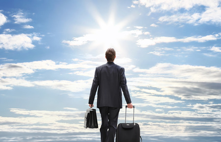 business man travel with trolley walking to the skyの写真素材