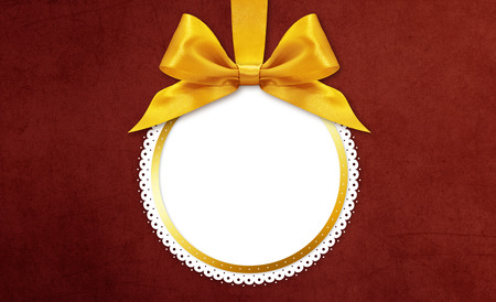 christmas ball with golden satin ribbon bow on red backgroundの写真素材