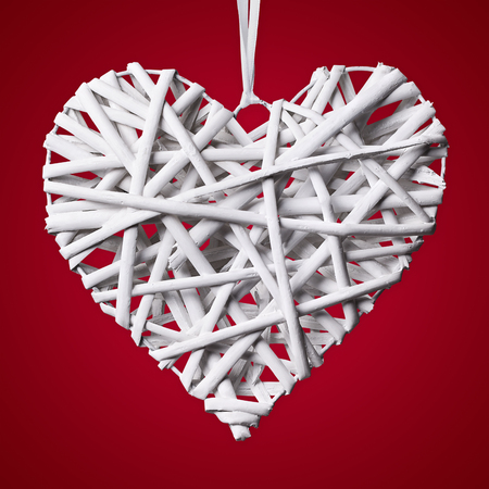Wooden Heart white braided isolated on red backgroundの写真素材