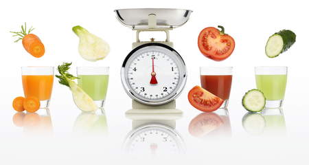 Balanced diet concept. weight scale and Vegetable juices in glass isolated on white background.の写真素材