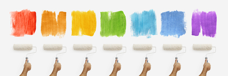 hand with roller paint on wall with colors samples, banner web template.の写真素材