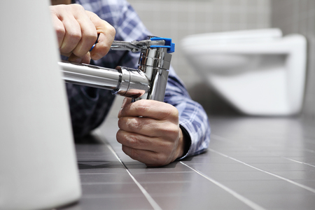 hands plumber at work in a bathroom, plumbing repair service, assemble and install concept.の写真素材