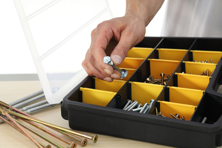 hand worker choose a nut bolts from the box, close up.の写真素材
