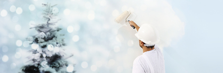 wish a merry christmas concept, painter with painting a Christmas tree on a white wall.の写真素材