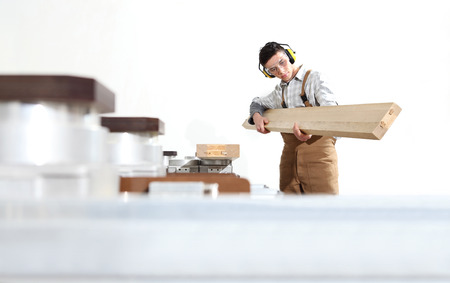 carpenter man works with wooden planks in the joinery, with computer numerical control center, cnc machine, isolated on a white background,の写真素材