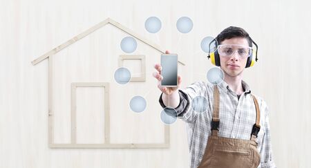 house construction renovation concept handyman carpenter show the mobile phoneの写真素材