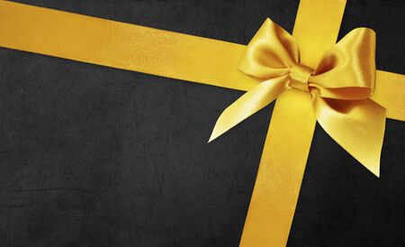 black gift card with golden ribbon bow, black friday concept.