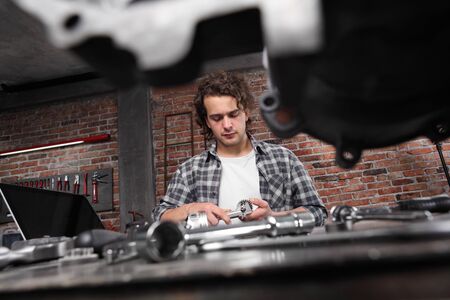 man working with caliper to measure the motor gear, study on the computer and search the internet
