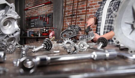 man work brush part of the engine with wire brush,  repair and cleaning motor on the workbench full...