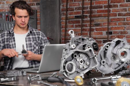 man working with caliper to measure the motor gear, study on the computer and search the internetの写真素材