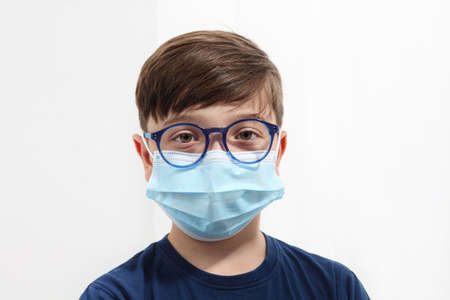 smiling child in hospital bed with teddy bear wearing protective mask, corona virus covid 19 protection concept,の写真素材