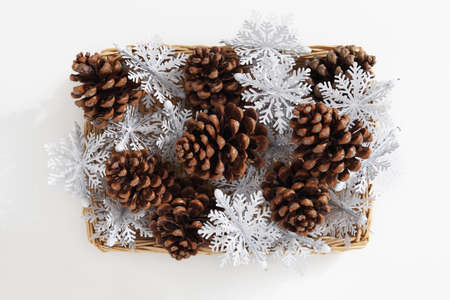 Christmas decorations, top view of a group of large pine cones and snow flake inside a wicker...