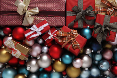 merry christmas, top view of wrapped gift present packages and colored balls decorations, useful as a greeting gift card backgroundの写真素材
