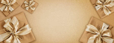 merry christmas, top view of wrapped gift packages of champagne color with golden ribbon bow, isolated on beige background, useful as a greeting gift cardの写真素材