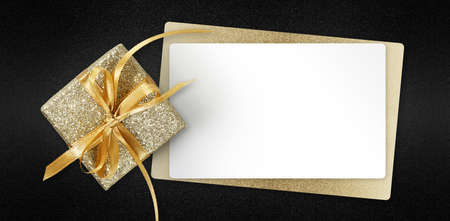 Black Friday gift card with golden glittering package and blank white ticket isolated on black background, template for promotional card with copy spaceの写真素材