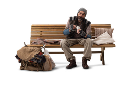 A man sitting on a wooden bench, eating from a tin can, isolated on a white background.の写真素材