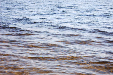 Texture: Bottom of the lake covered by stones seen through wavesの写真素材