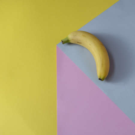 Banana on a gray background. Against pink and yellow background. Minimal conceptの写真素材