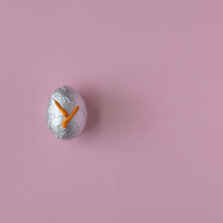 Easter egg on a pastel pink background with creative copy space. Minimal Easter holiday concept