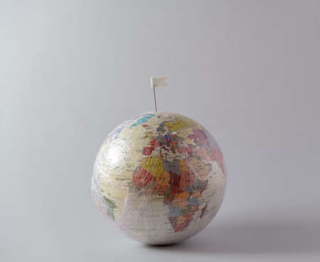 Planet Earth in stretch wrap  plastic with a white flag. Minimal enviromental concept.