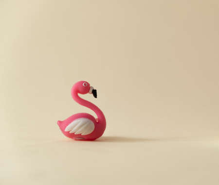 Rubber flamingo on a yellow background. Trendy summer concept