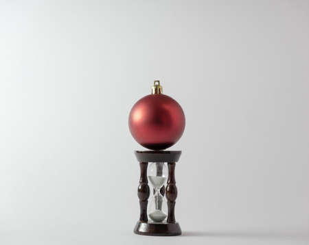 Christmas ball and hourglass on a white background. New Year's concept