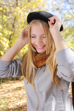 Funny laughing blond girl wearing a hat in autumn parkの写真素材