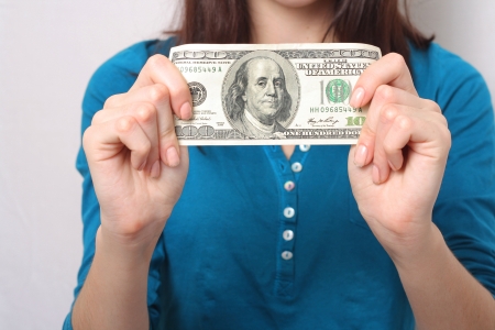 Young girl holding  one hundred dollars bank note