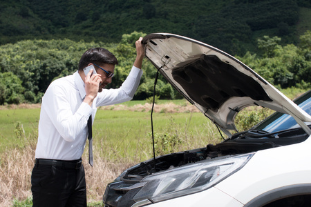 Man call for help on the phone.Are can not continue the way because of the broken car.の写真素材