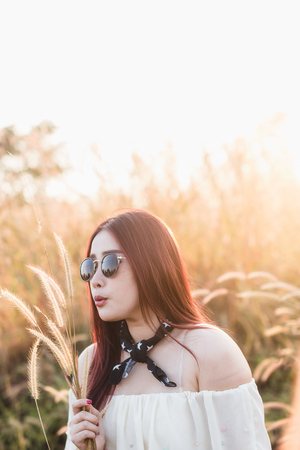 Young woman standing in forest and bush in sunny rays field at sunset in summer meadow.Are looking...
