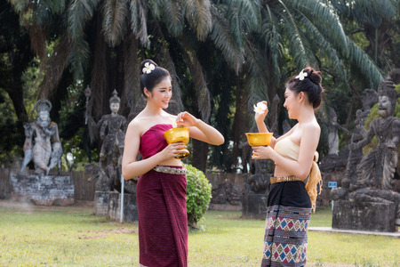 Beautiful Laos girl in Laos costume. Asian woman wearing traditional Laos culture at the temple. Beautiful Laos girl splashing water during tradition festival Laos Vientiane.のeditorial素材